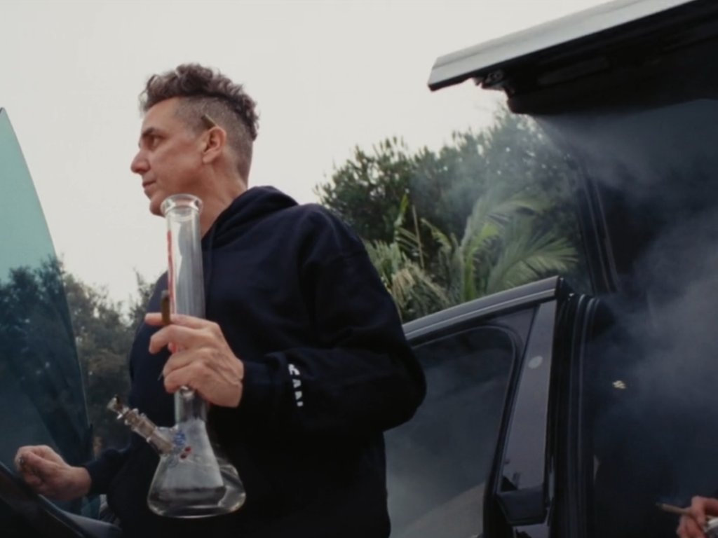 Producer Mike Dean arrives with a bong in hand